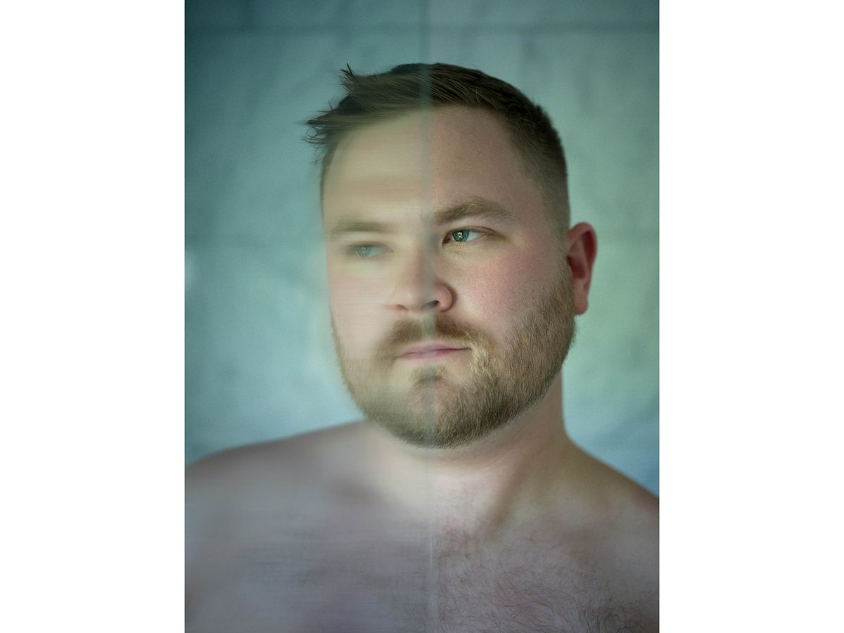 Spread 6 of 18 from Twin Palms: a close portrait of a bearded man's face and bare shoulders in a two-tone colour treatment; colour.