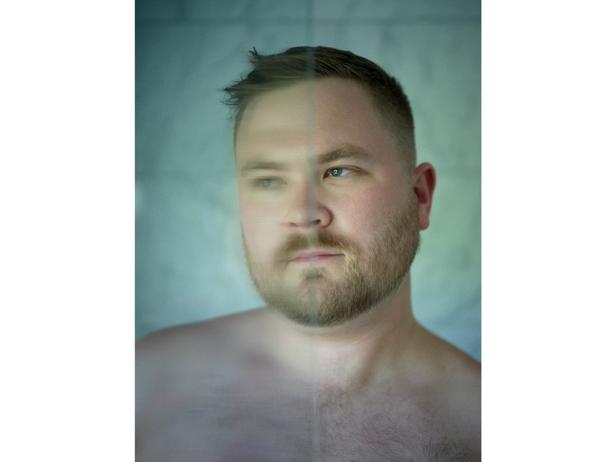 Spread 11 of 18 from Twin Palms: a close portrait of a bearded man's face and bare shoulders in a two-tone colour treatment; colour.
