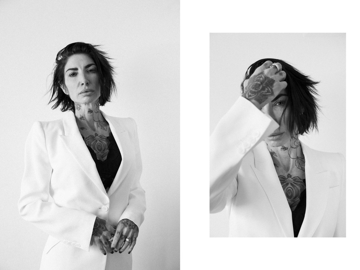 Spread 1 of 6 from Force of Nature: two photographs of a tattooed woman in a white blazer, one with hair across her face; black and white.
