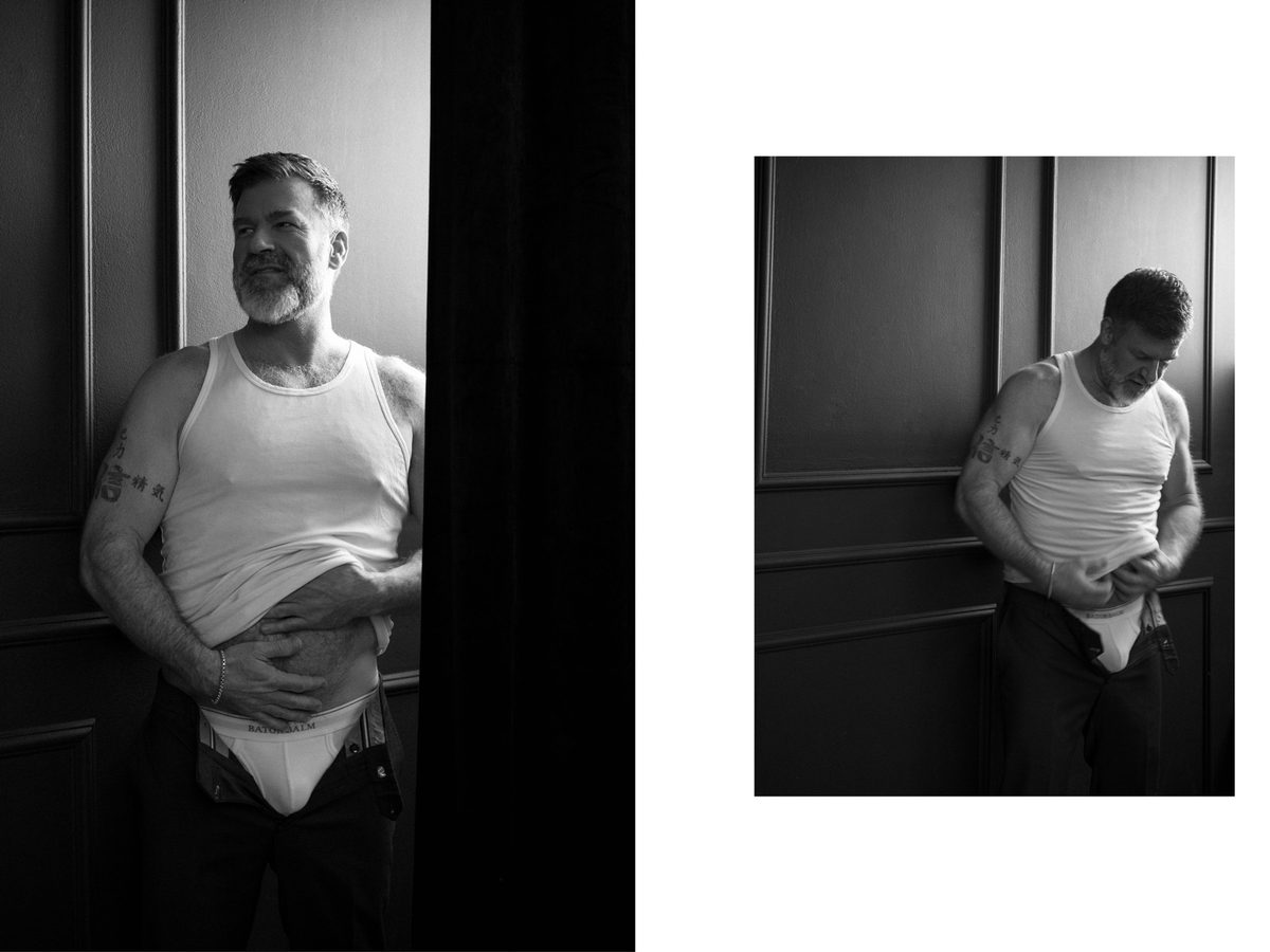 Spread 1 of 8: two photographs of a bearded, grey-haired man in a tank top and briefs, standing against a dark wall; black and white.