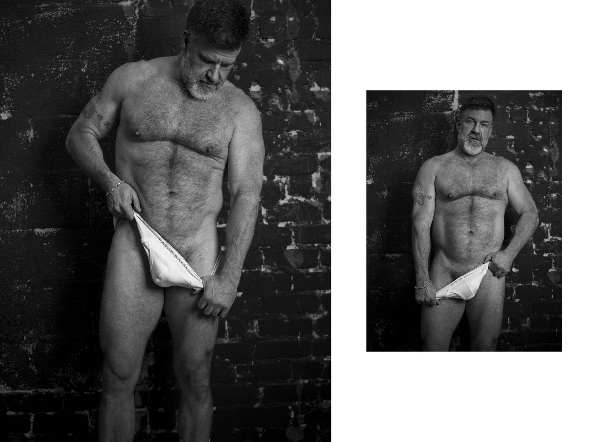 Spread 5 of 8: two photographs of a bearded, grey-haired, hairy-chested man lowering white briefs against a brick wall; black and white.